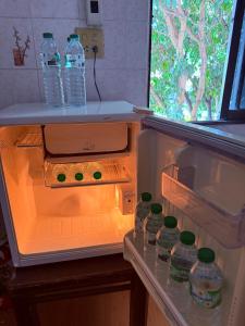 an open refrigerator with bottles of water in it at Lawans Hostel in Pattaya South