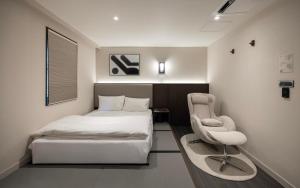 a bedroom with a bed and a chair in it at 아늑료칸 동대구역점 in Daegu
