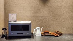 a microwave sitting on a counter next to a wall at Myeongwolga Poolvilla in Busan