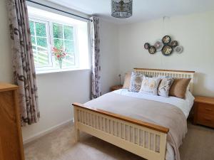 a bedroom with a bed and a window at Colby Hall Cottage in Colby