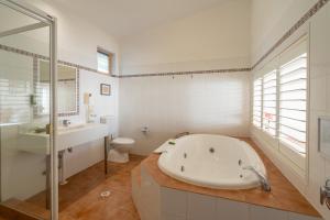 a white bathroom with a tub and a toilet at Eagle Heights Mountain Resort in Eagle Heights +31 photos