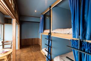 a room with bunk beds with a desk and a table at Saitosyukuba in Sonogi +10 photos