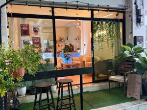 a store window with stools and plants at Lawans Hostel in Pattaya South