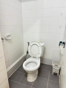 a bathroom with a toilet and a trash can at Lawans Hostel in Pattaya South +17 photos