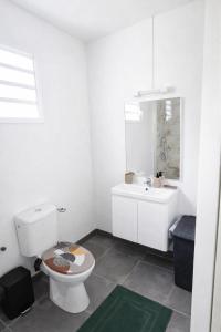 a white bathroom with a toilet and a sink at Kaza Domi studio in Le Lamentin
