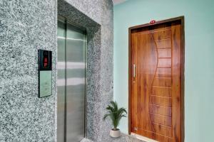 a wooden elevator door with a potted plant next to it at Super Collection O The Kailash Hotel in Dehradun
