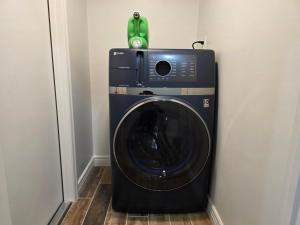 eine Waschmaschine mit einem grünen Telefon darauf in der Unterkunft Private Basement 1mi UVU 3 Parking in Orem