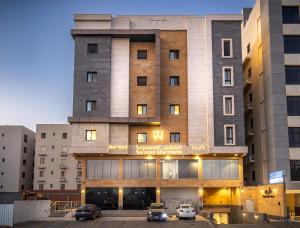 a building with cars parked in a parking lot at دار ود للشقق المخدومة Dar Wed in Jeddah