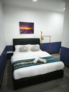 a bedroom with a large bed with a black headboard at 爱上海蓝蓝屋民宿 Blue Ocean Station in Penampang +40 photos