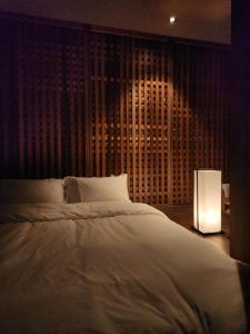 a bedroom with a large white bed and a lamp at Myeongwolga Poolvilla in Busan