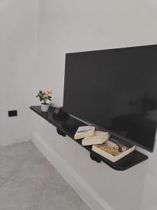 a black shelf on a wall with books on it at Galápagos Islands-Apartment in Santa Cruz in Puerto Ayora +2 photos