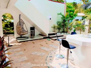 a patio with chairs and a table and a fireplace at Chief's Villa Malapascua Island Dorm with Hot Shower & Outdoor Kitchenette in Malapascua Island