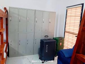 a locker room with luggage and lockers and a suitcase at Chief's Villa Malapascua Island Dorm with Hot Shower & Outdoor Kitchenette in Malapascua Island