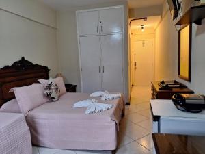 a bedroom with a bed with two towels on it at Flats Cavalinho Branco 405 ou 603 in Águas de Lindoia