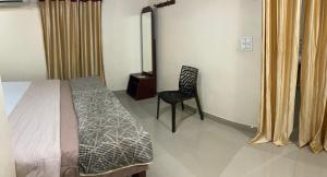 a bedroom with a bed and a chair in it at Kakkakuni heritage in Kozhikode