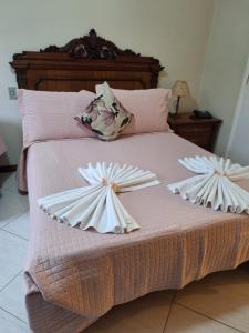 a bed with two paper flowers on it at Flats Cavalinho Branco 405 ou 603 in Águas de Lindoia