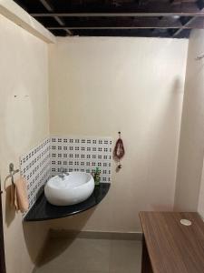 a bathroom with a sink on a black counter at Kakkakuni heritage in Kozhikode