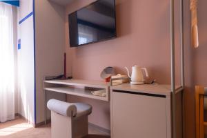 a room with a desk with a tv on the wall at THE BASEMENT HOTEL OsakaHonmachi in Osaka