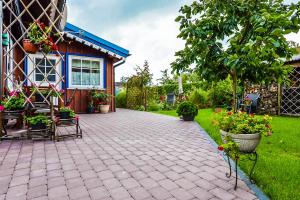 a patio with chairs and flowers in front of a house at Lana in Nida