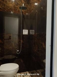 a bathroom with a shower with a toilet and a glass shower at Chief's Villa Malapascua Island Dorm with Hot Shower & Outdoor Kitchenette in Malapascua Island