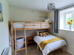 a bedroom with two bunk beds and a bed at Colby Hall Cottage in Colby +2 photos