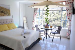 a bedroom with a bed and a table with chairs at Hotel Alta Montaña Mongui By Seres Viajeros in Monguí