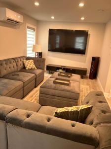 a living room with two couches and a flat screen tv at Hamptons Tiana Bay Oasis in Hampton Bays