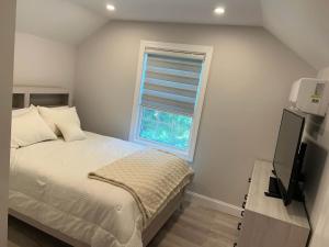 a small bedroom with a bed and a window at Hamptons Tiana Bay Oasis in Hampton Bays +27 photos
