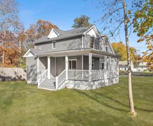 a gray house with a porch and a yard at Hamptons Tiana Bay Oasis in Hampton Bays
