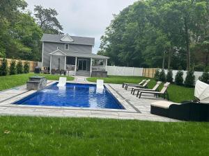 a swimming pool in a yard with a house at Hamptons Tiana Bay Oasis in Hampton Bays
