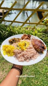 a person holding a plate of food with rice and meat at Kakkakuni heritage in Kozhikode