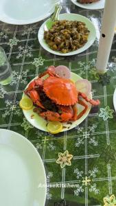 a crab on a plate on a table with food at Kakkakuni heritage in Kozhikode +12 photos