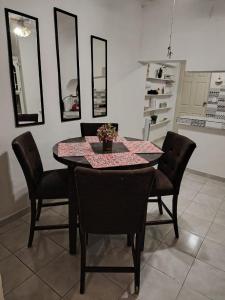 a dining room with a table with black chairs and a tableablish at Casa centrica in Hermosillo