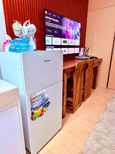 a white refrigerator in a kitchen with a table at TIRPT Staycation in Manila