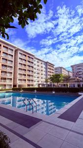 a large apartment building with a large swimming pool at TIRPT Staycation in Manila