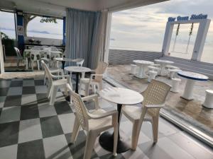 a restaurant with tables and chairs and a view of the ocean at 爱上海蓝蓝屋民宿 Blue Ocean Station in Penampang