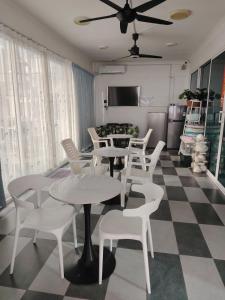 a dining room with white tables and white chairs at 爱上海蓝蓝屋民宿 Blue Ocean Station in Penampang
