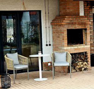 two chairs and a table on a patio at Villa Lazarina Vineyard Views in Kvareli
