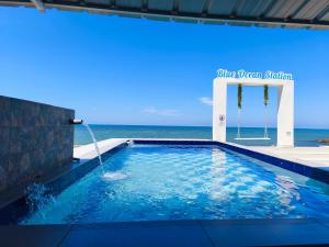 a swimming pool with the ocean in the background at 爱上海蓝蓝屋民宿 Blue Ocean Station in Penampang