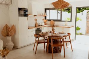 a kitchen with a table and chairs and a kitchen with a window at Lodge des palmiers - jacuzzi in Salazie
