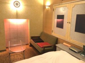 a small room with a couch and a bed at ホテルアドレ大人専用 in Hachinohe