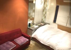 a hospital room with a bed and a mirror at ホテルアドレ大人専用 in Hachinohe