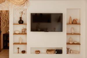 a living room with a flat screen tv on a wall at Lodge des palmiers - jacuzzi in Salazie