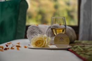 a glass of wine sitting on a table with a plate at Hotel grandlords in Pahalgām +10 photos