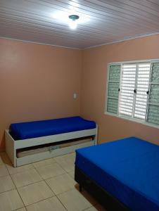 a bedroom with two beds and a window at Ampla acomodação e com ótimo localização in Machadinho