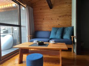 a living room with a blue couch and a wooden table at 宿すごろく-Sugoroku Inn- in Nagahama