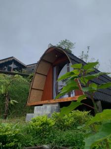 a tree house with a window on a hill at Giri Garden Sunset Glamping in Gitgit
