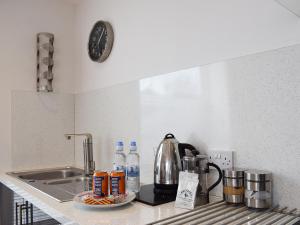 a kitchen counter with a sink and a coffee maker at Bramble Cottage in Leven