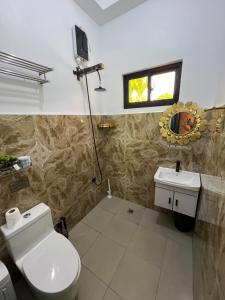 a bathroom with a toilet and a sink and a mirror at Dutch Guest House Studio in Siquijor