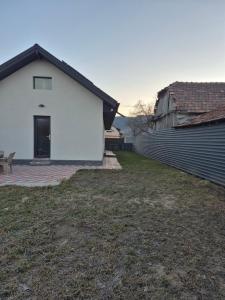 a white house with a fence and a yard at La Mariana in Comăneşti
